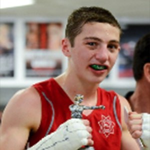 2015 scholarship winner Rosino Legan holding up mma trophy