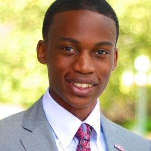 Headshot of 2017 scholarship winner Jeremy Coleman outside, dressed in a gray suit and tie