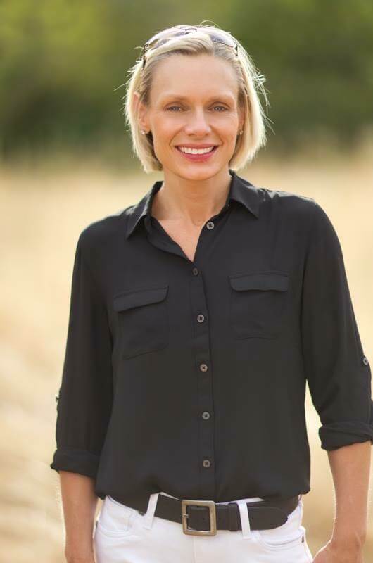 Upper body shot of Ms. Sara Lindberg wearing a black button up shirt, she has short blonde hair