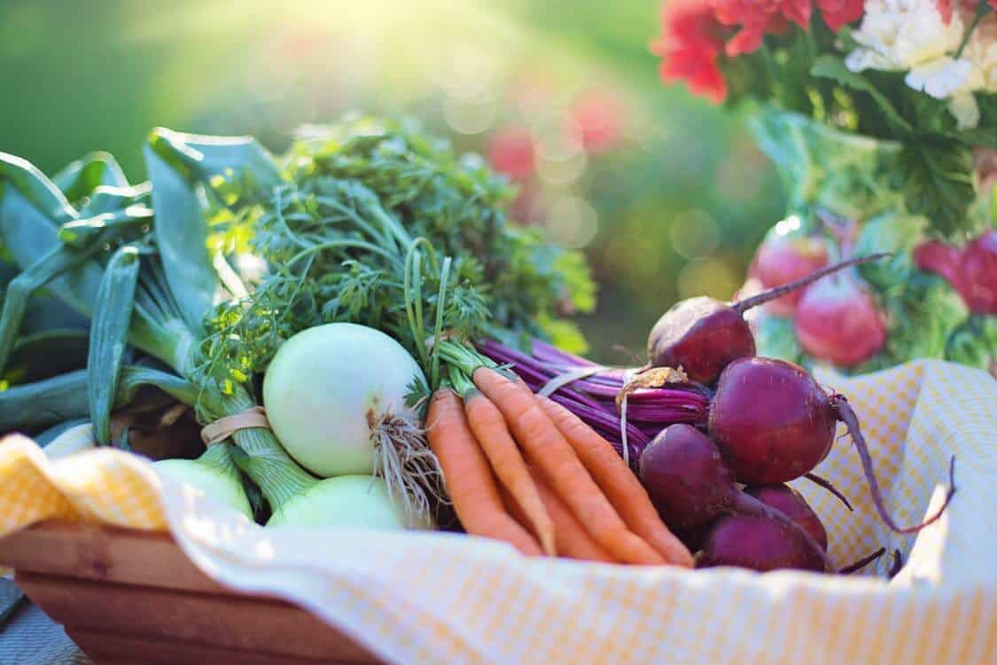 Basket of fresh onion, carrots, and beets